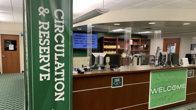 Image of the circulation desk with plexiglass guards installed