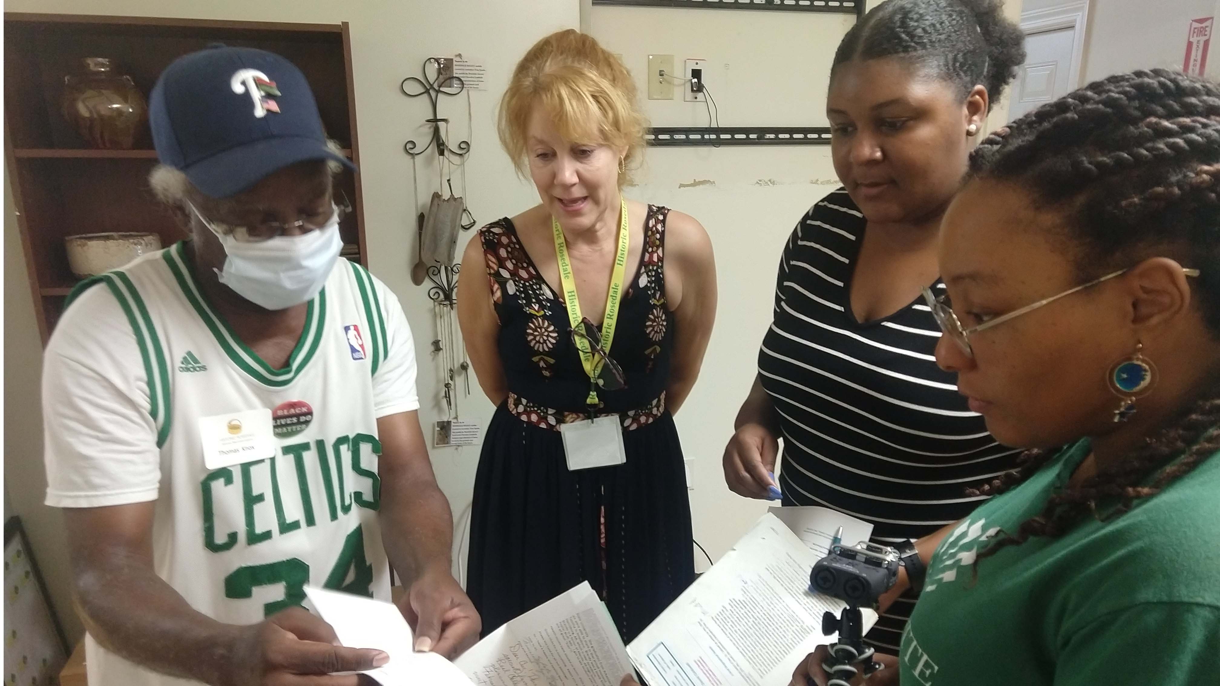 A man shows three people some papers