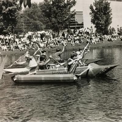 Students rowing handmade boats.