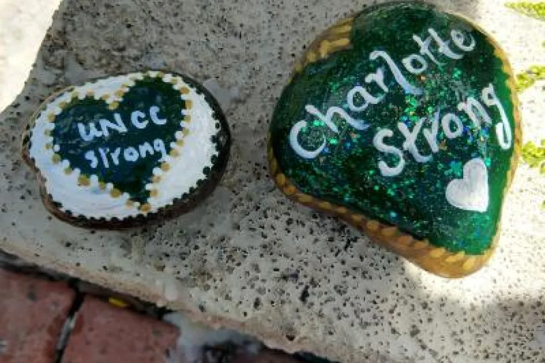Stones painted with the words Charlotte Strong and UNCC Strong